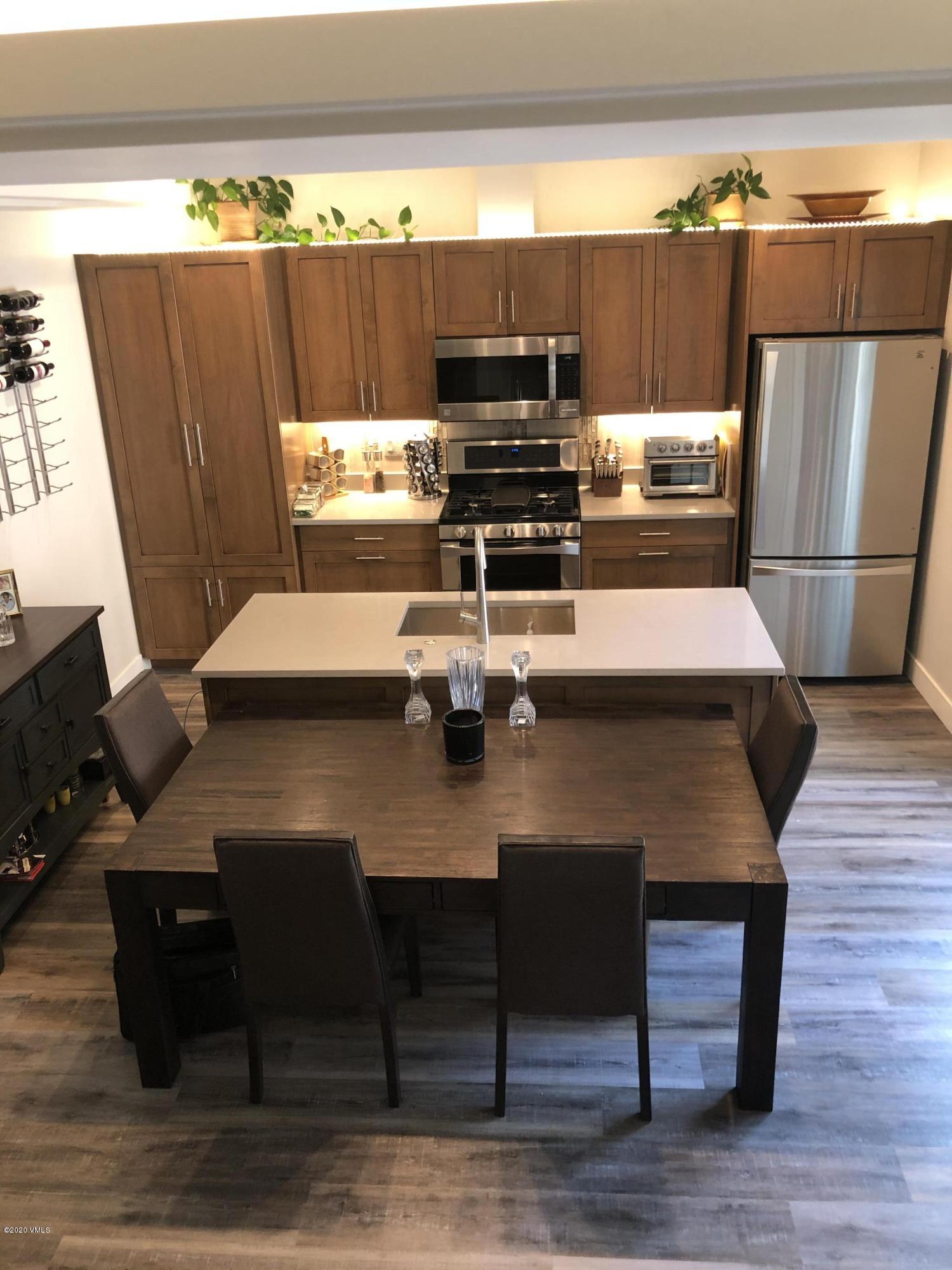 316 Wall Street, Unit 6 Eagle, CO 81631 - Photo 9 of 30 a kitchen with a wooden floor and a refrigerator