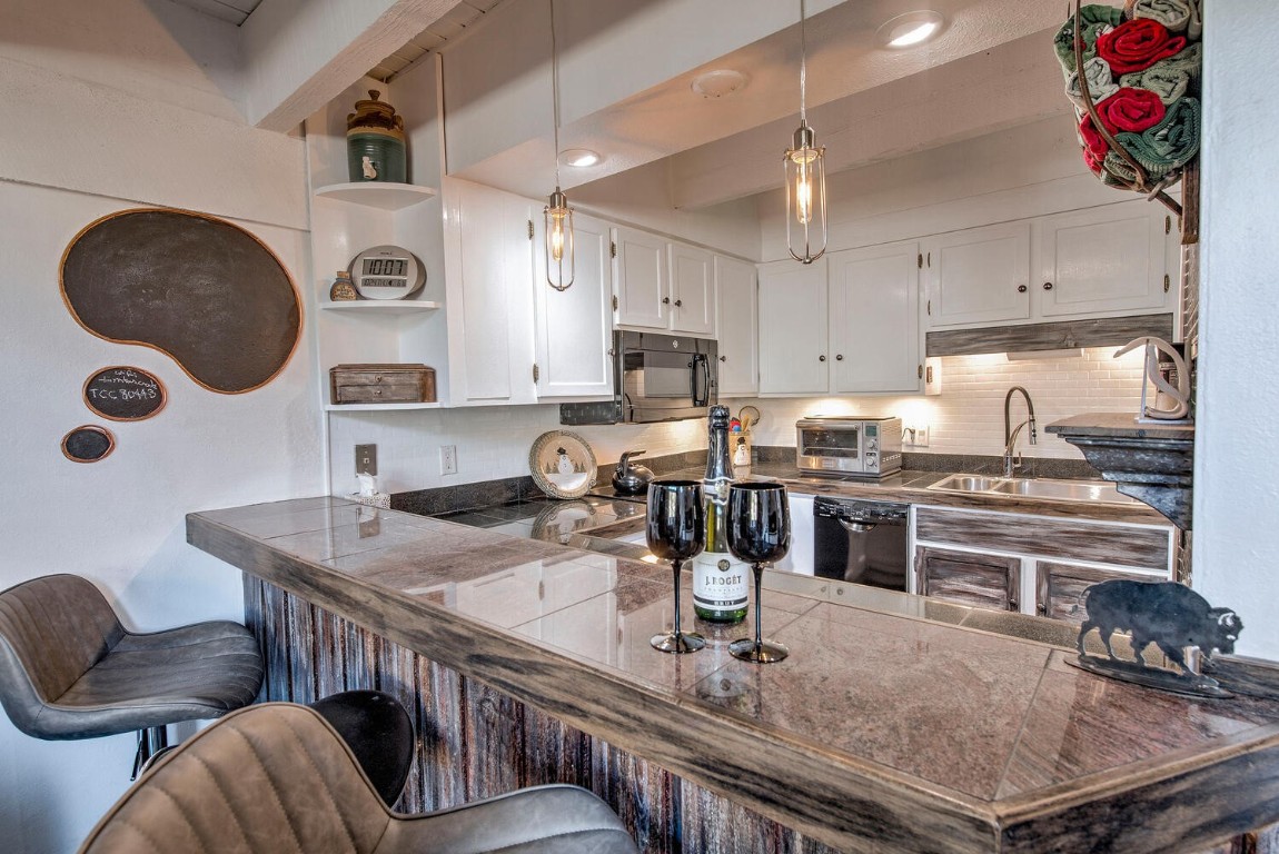 78 Guller Road, Unit 201 Copper Mountain, CO 80443 - Photo 13 of 41 a kitchen with stainless steel appliances granite countertop a stove a refrigerator a sink dishwasher a dining table and chairs with wooden floor