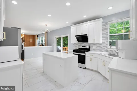 a kitchen with stainless steel appliances granite countertop a stove top oven a sink dishwasher and a refrigerator