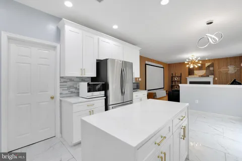 a kitchen with a refrigerator a stove top oven a sink and cabinets