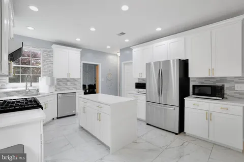 a kitchen with white cabinets and white appliances