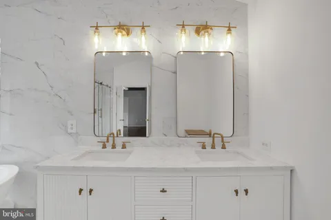 a bathroom with double vanity sinks and a mirror