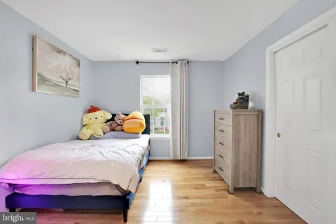 a bedroom with a bed and wooden floor