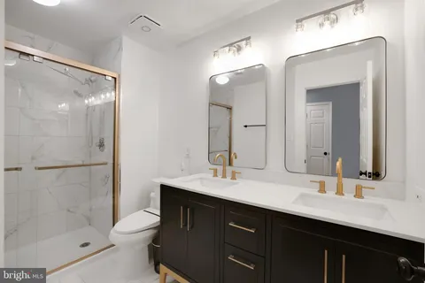 a bathroom with a double vanity sink mirror double and shower