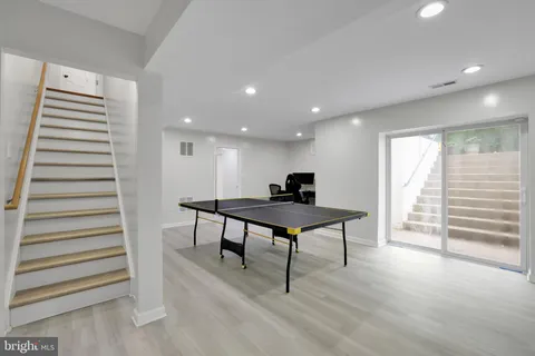 a view of a room with wooden floor stairs and windows