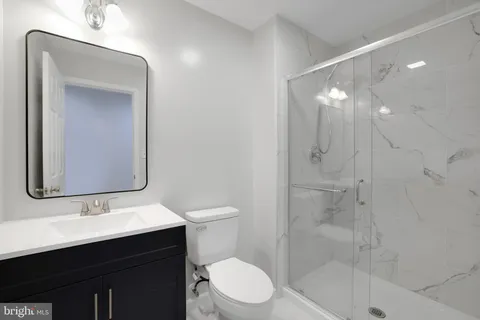 a bathroom with a sink toilet a mirror and shower