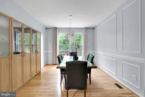 a view of a a dining room with furniture window and wooden floor