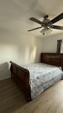 a bedroom with a bed and wooden floor