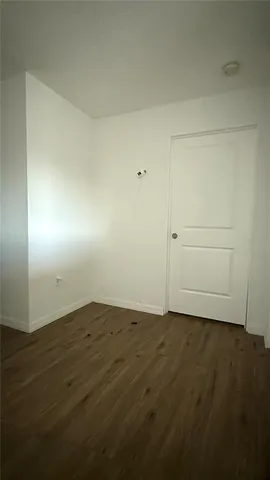 an empty room with wooden floor and cabinet