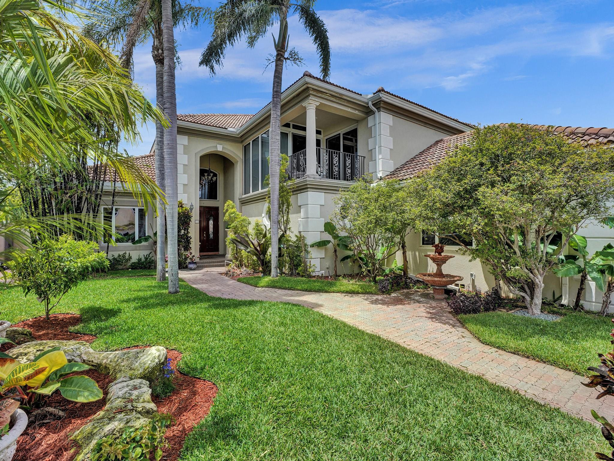 21 Saranac Road Sea Ranch Lakes, FL 33308 - Photo 4 of 35 a front view of a house with a yard table and chairs
