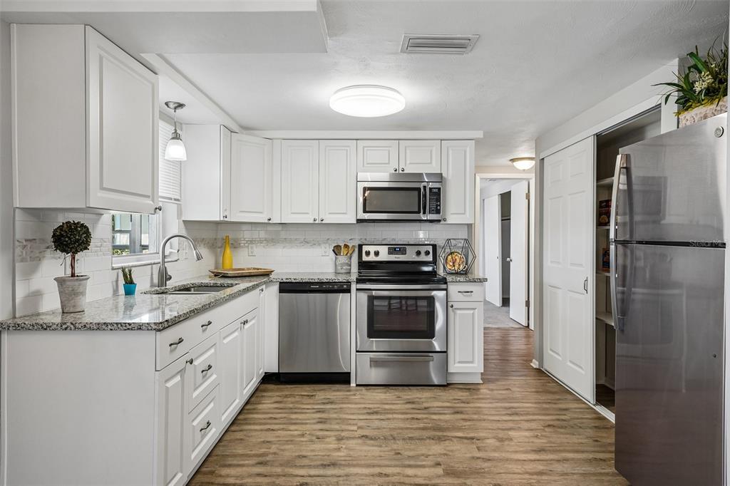 7215 Mayfield Drive Port Richey, FL 34668 - Photo 24 of 52 a kitchen with a sink appliances and cabinets