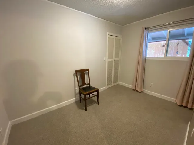 an empty room with windows and closet