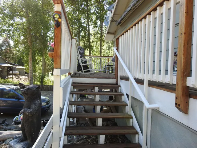 a view of a barn house next to a yard with large trees