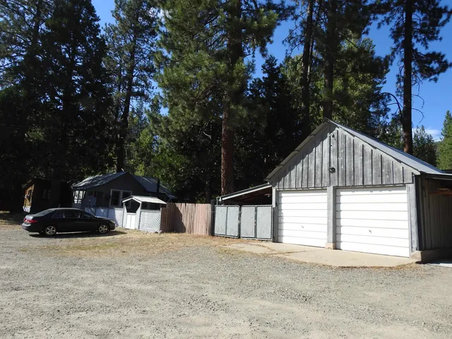 a view of a house with wooden fence and a bench