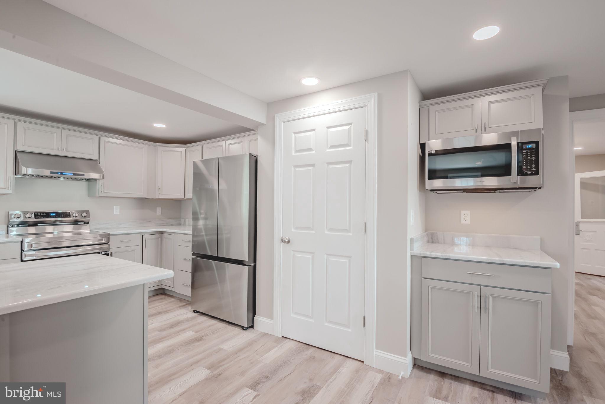 319 Union Street Milton, DE 19968 - Photo 11 of 61 a kitchen with white cabinets and stainless steel appliances