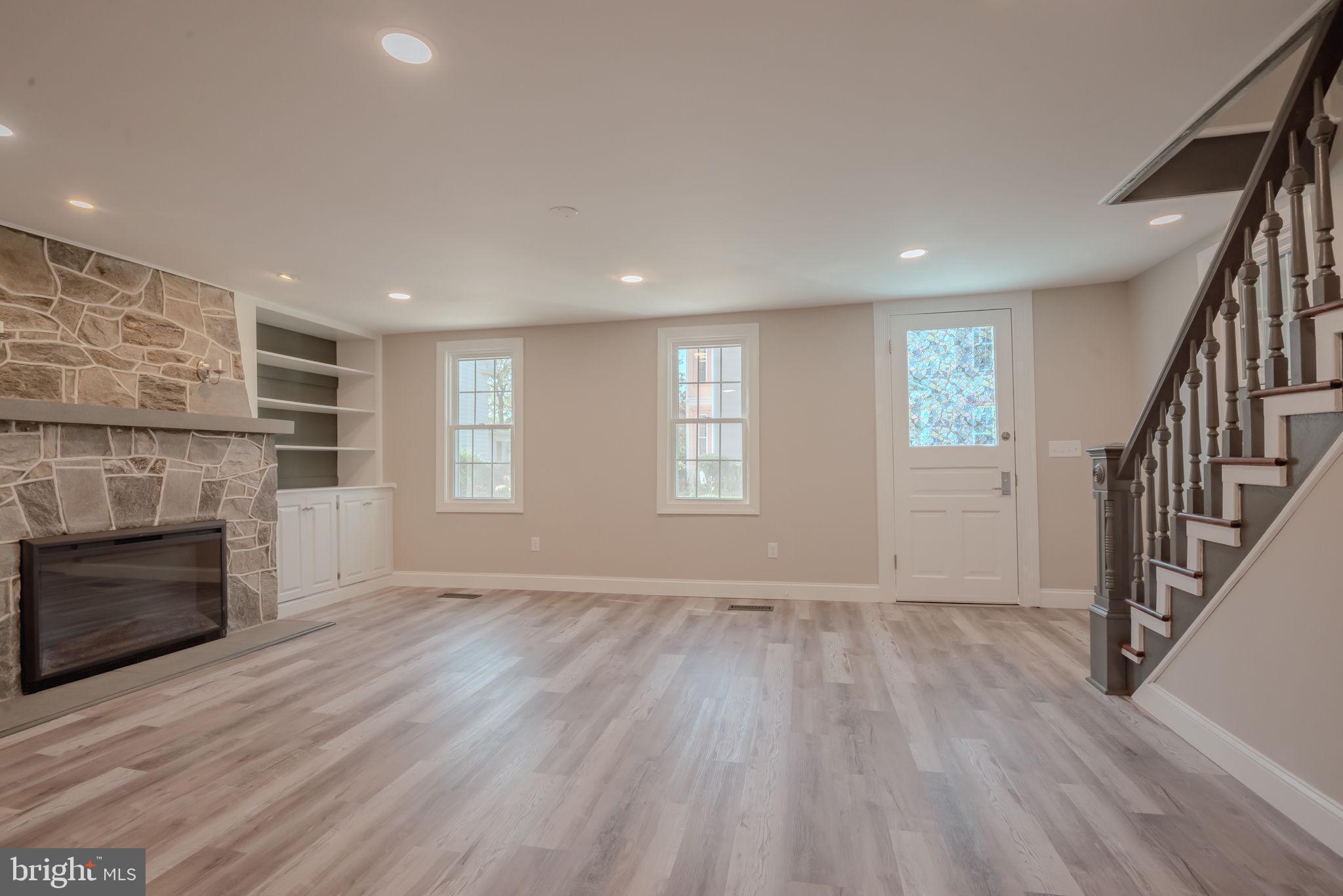 319 Union Street Milton, DE 19968 - Photo 19 of 61 an empty room with wooden floor fireplace and windows