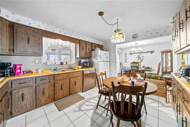 a kitchen with a dining table chairs sink and cabinets