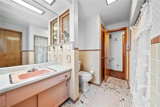 a bathroom with a sink toilet vanity and shower