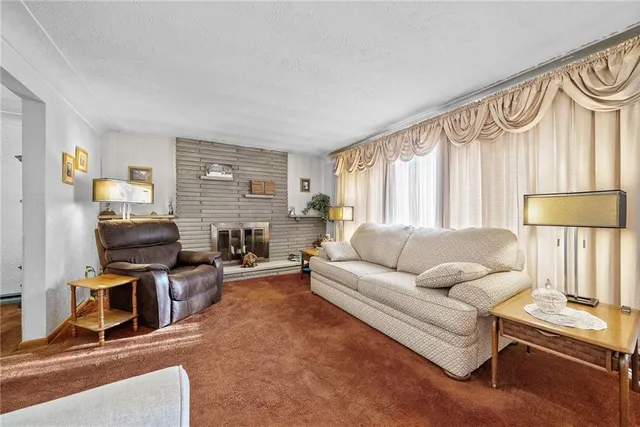 a living room with furniture a flat screen tv and a window