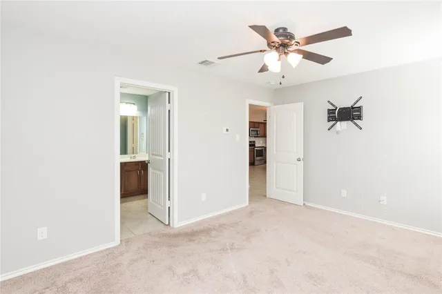 an empty room with a ceiling fan and a window