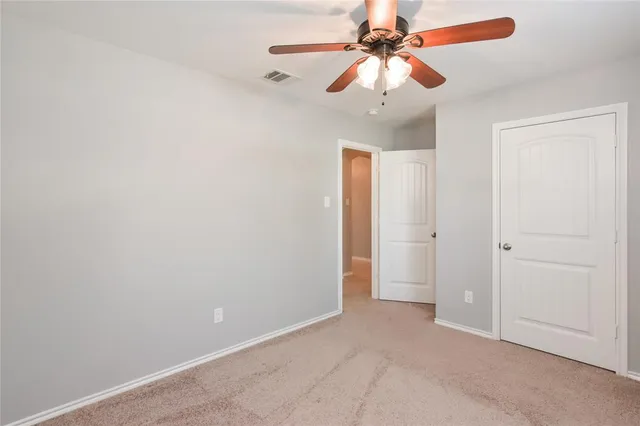 an empty room with fan and entryway