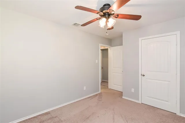 an empty room with a fan and a fan