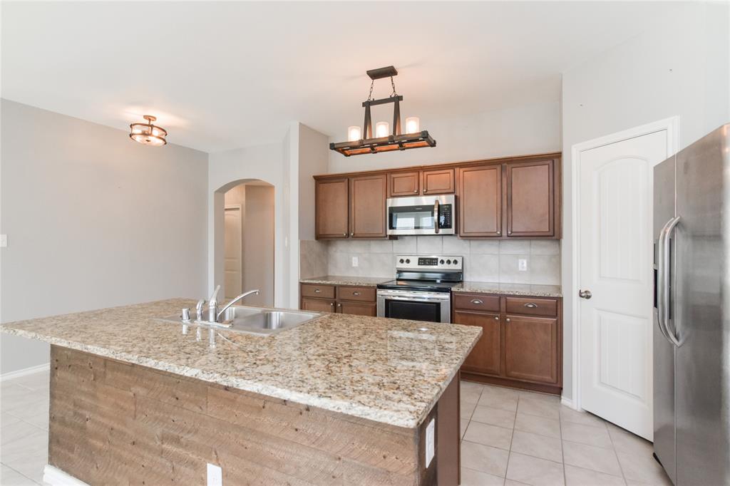 1406 Slate Street Princeton, TX 75407 - Photo 4 of 25 a kitchen with stainless steel appliances granite countertop a sink stove and refrigerator