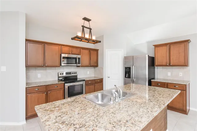 a kitchen with stainless steel appliances granite countertop a sink stove and refrigerator
