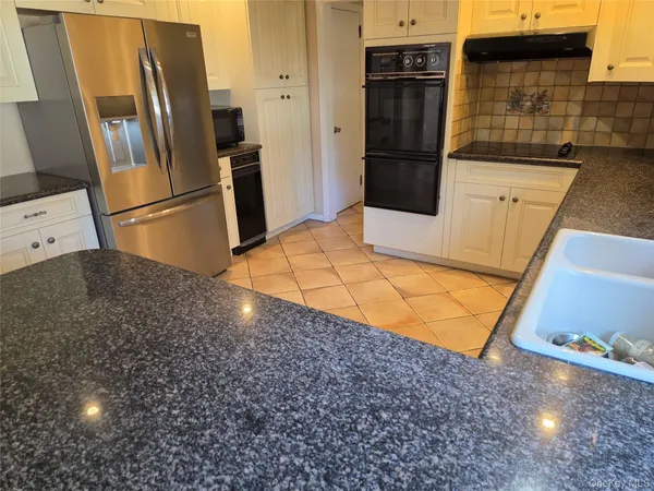 a kitchen with stainless steel appliances granite countertop a refrigerator and a sink