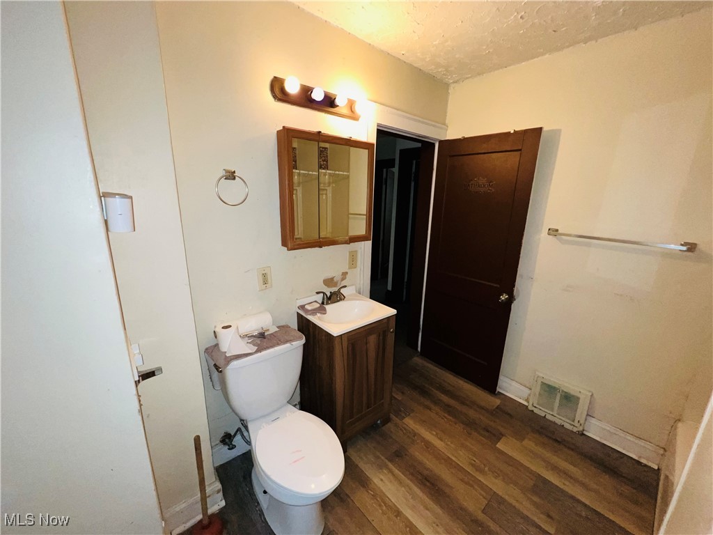 968 Whitby Road Cleveland Heights, OH 44112 - Photo 7 of 19 Bathroom featuring vanity, dark wood-type flooring, and a textured ceiling