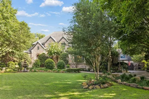 a front view of a house with a garden and plants