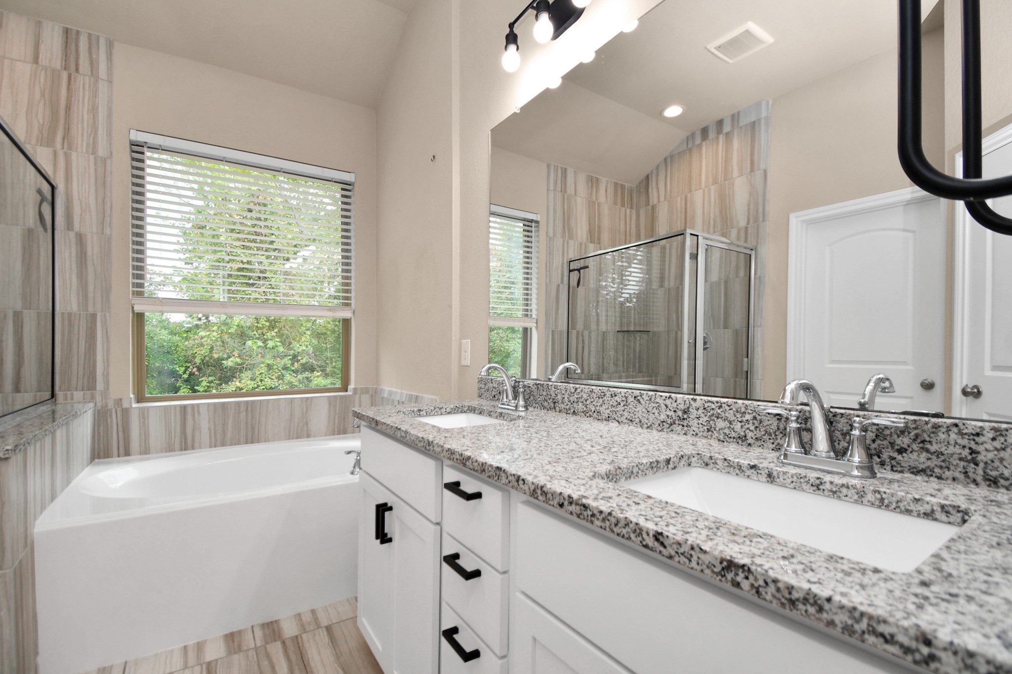 4220 Merry Mill Drive Spring, TX 77386 - Photo 25 of 44 a bathroom with a granite countertop bathtub a sink and a large mirror