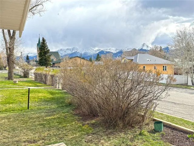 a view of a house with backyard and tree