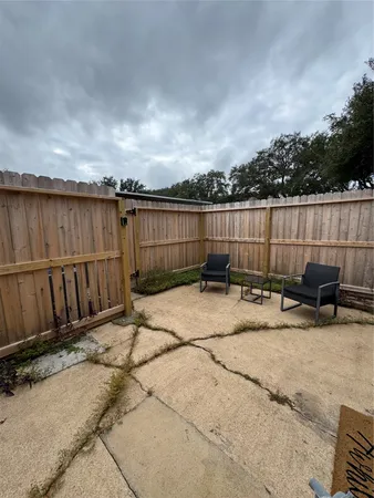 a view of a backyard with a large tree and wooden fence