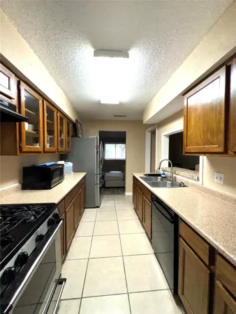 a large kitchen with stainless steel appliances granite countertop a stove and a sink
