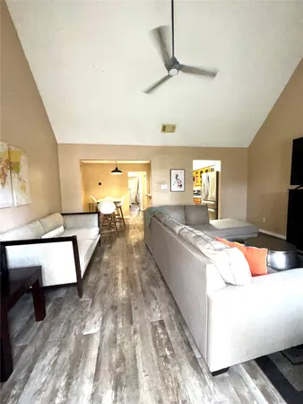 a living room with stainless steel appliances granite countertop furniture and a flat screen tv