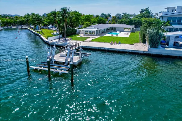 an aerial view of a house with swimming pool and a yard