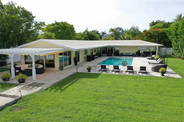 a view of a patio with table and chairs under an umbrella