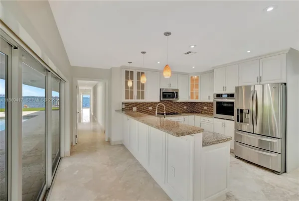 a large kitchen with a large window and stainless steel appliances