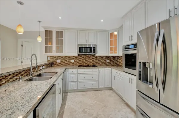 a kitchen with granite countertop a sink stove and refrigerator