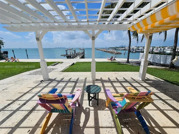 a view of a patio with table and chairs with wooden floor and fence