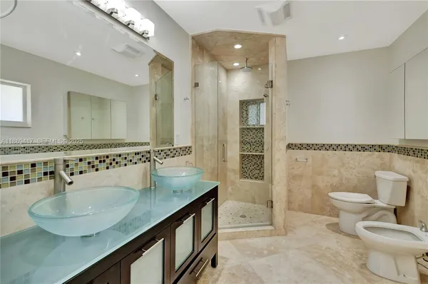a bathroom with a granite countertop sink a toilet a mirror and shower