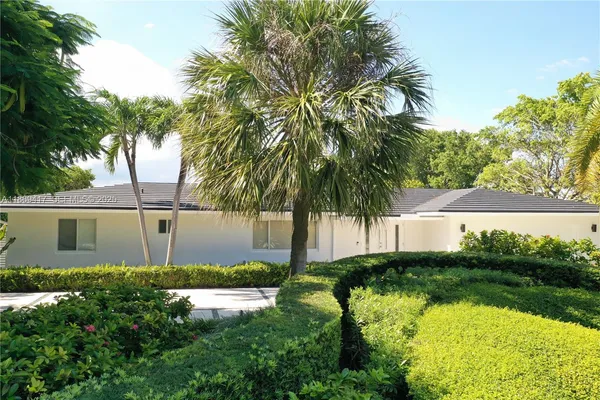 a backyard of a house with a garden and tree