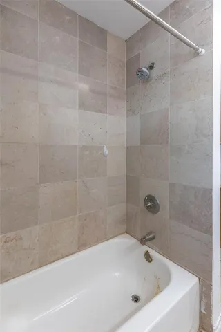 a white bath tub sitting next to a white sink and a shower