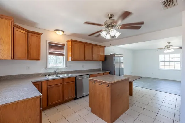 a kitchen with a stove a sink a refrigerator and cabinetry