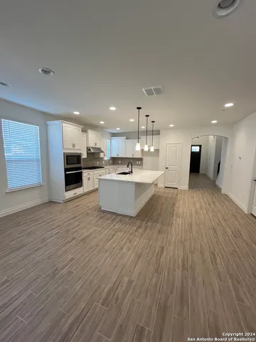 a living room with stainless steel appliances kitchen island wooden floor and view living room