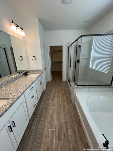 a spacious bathroom with a granite countertop double vanity sink and a bathtub