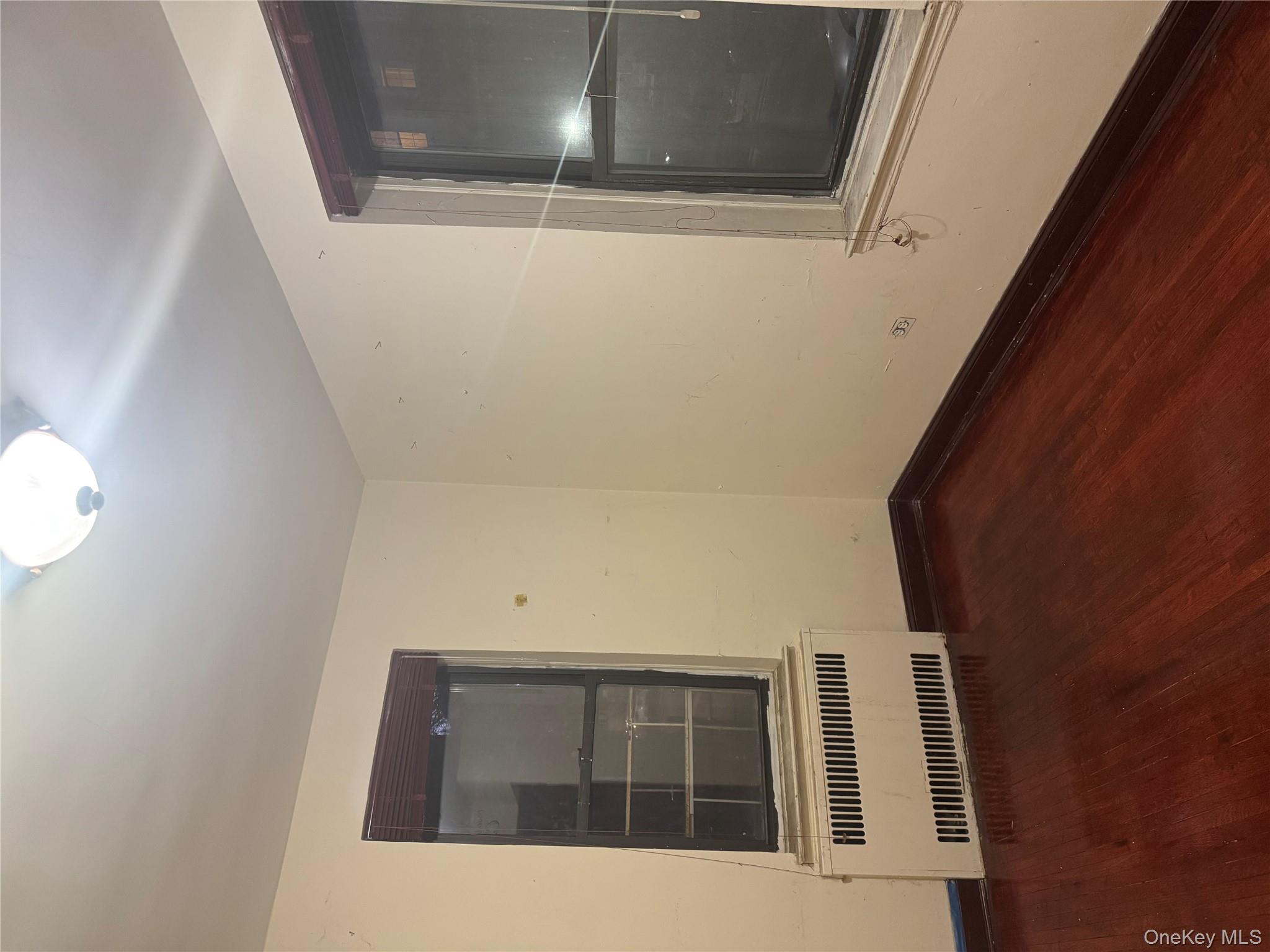 80-09 35th Avenue, Unit A12 Queens, NY 11372 - Photo 11 of 22 an empty room with wooden floor and windows