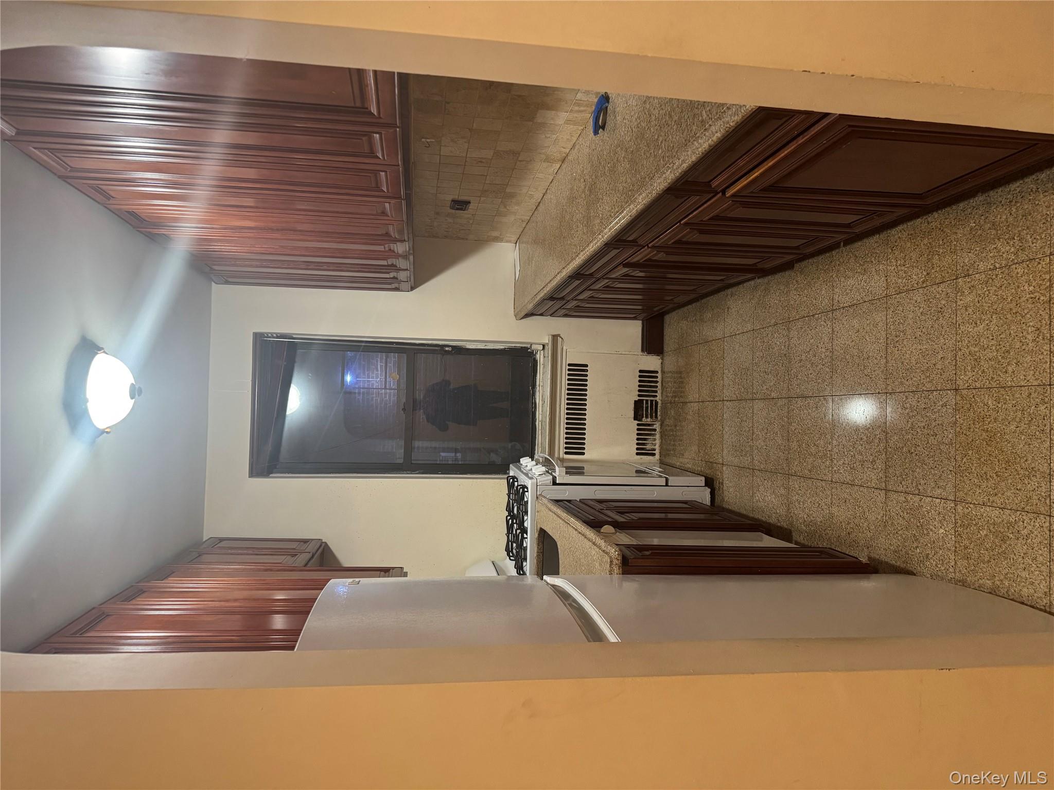 80-09 35th Avenue, Unit A12 Queens, NY 11372 - Photo 12 of 22 a kitchen with granite countertop a stove a sink and a refrigerator