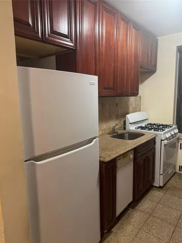 a kitchen with granite countertop stainless steel appliances and wooden cabinets